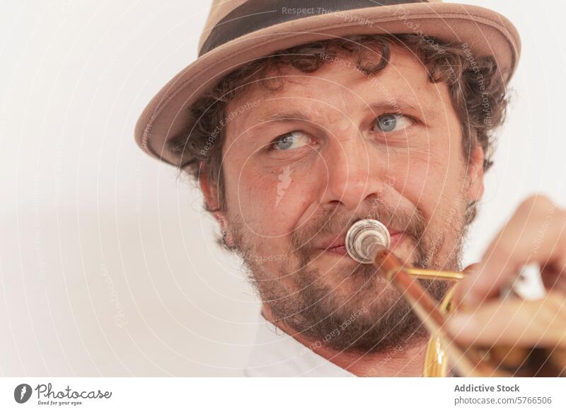 Determined musician practicing trumpet trumpeter one-armed practice home passion perseverance talent instrument hat determination hobby man adult caucasian