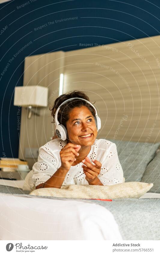 Joyful middle aged hispanic woman relaxing with music at home headphones listening smiling mature relaxation couch happy casual enjoyment leisure comfort adult