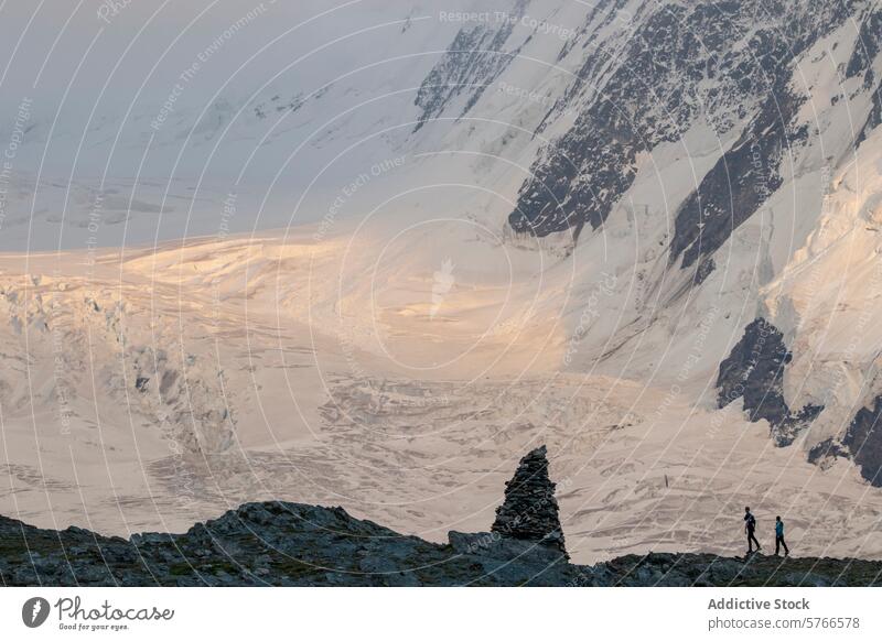 Hikers traverse a ridge with a breathtaking view of a glacier bathed in the warm alpine glow of the setting sun in the Swiss Alps hikers sunset mountain