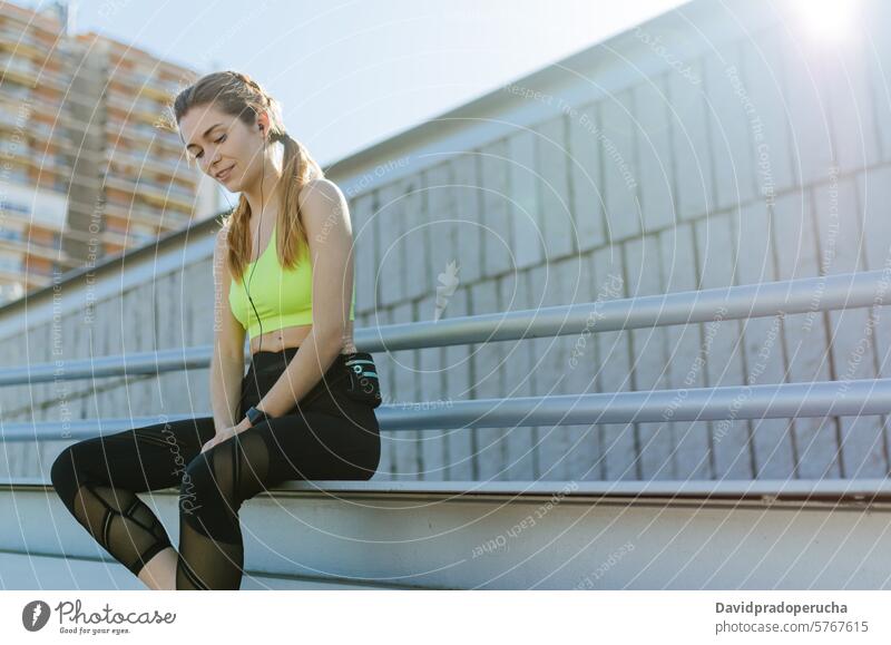 fit happy woman resting after do sport , running and workout fitness stretching exercise young training healthy listening music outdoor beautiful lifestyle park