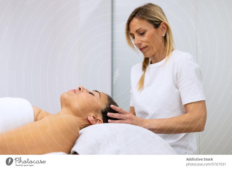 Masseuse doing a relaxing head massage adult alternative medicine beauty body care bodycare caucasian craniofacial enjoyment eyes closed face female hand
