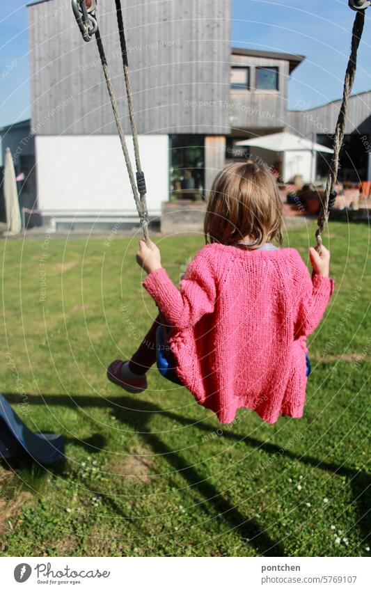 a small child swings in the garden To swing Swing Child Infancy Joy Garden pink Spring sunny Playing Movement Joie de vivre (Vitality) Leisure and hobbies