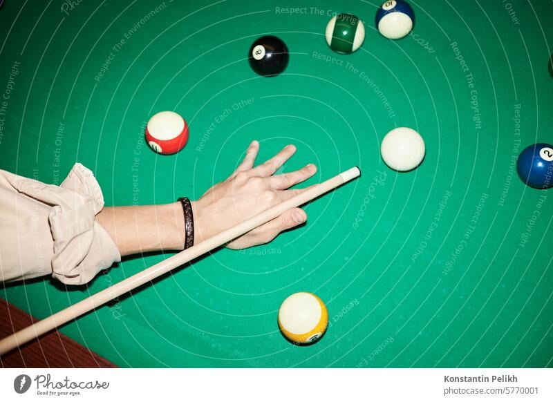 Close up of unrecognizable man playing billiard at green pool table with camera flash copy space close up hand male game hold cue stick aim hit shot ball bar