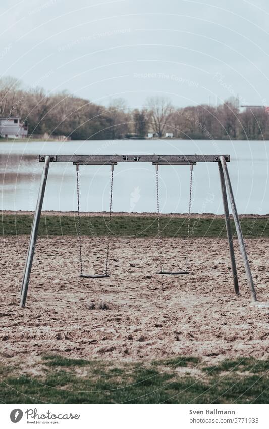 Empty swing in front of the lake Deep depth of field Absence Central perspective straightforwardness relaxation color photograph Concept photo nobody