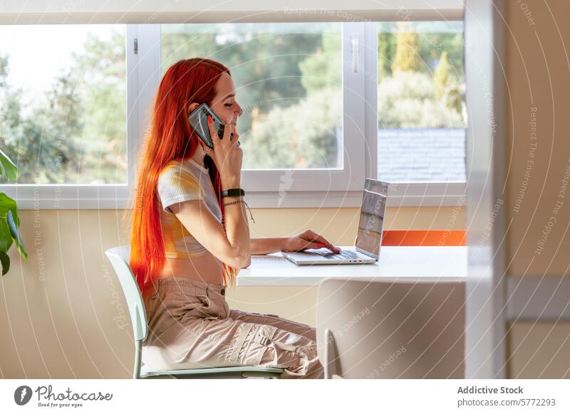 Redheaded Woman Planning a Nature Getaway on Phone and Laptop woman redhead nature getaway phone laptop planning conversation seated room greenery window