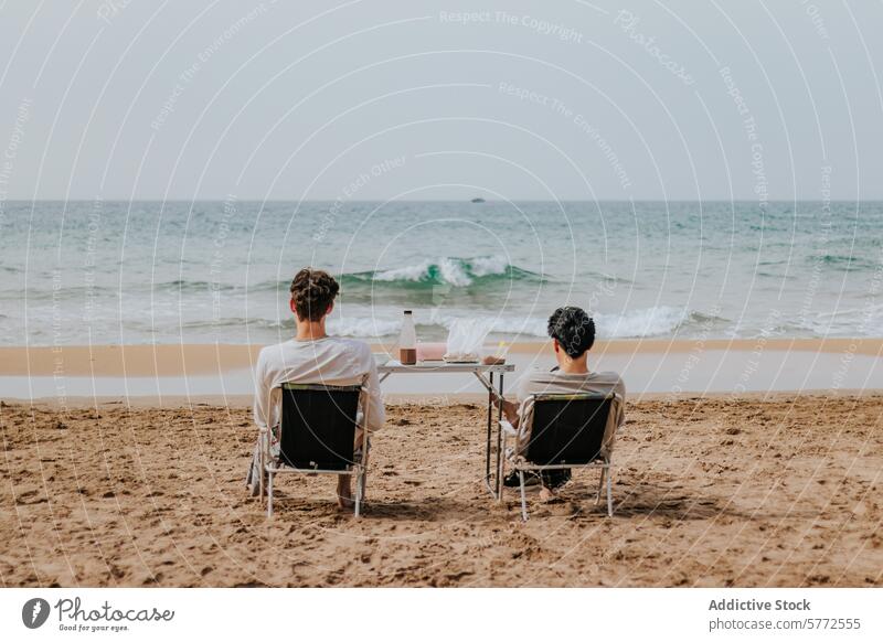 Couple enjoying a peaceful day at the beach couple ocean sitting chairs sand relaxation shore seaside wine glasses table horizon serene leisure vacation
