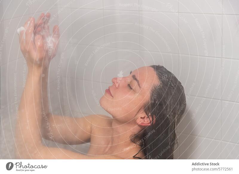 Refreshing shower moment for a young woman water wet hair refreshing soapy bath hygiene personal care bathroom tile cascade catching cleansing droplets moisture