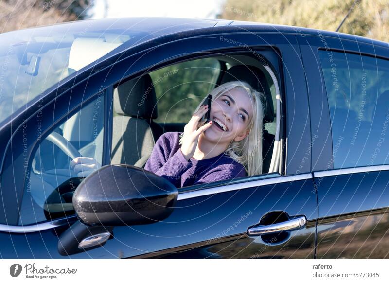 Blonde talking on phone in car communication woman blonde call chat mobile driving seated vehicle purple sweater smile happy conversation technology wireless