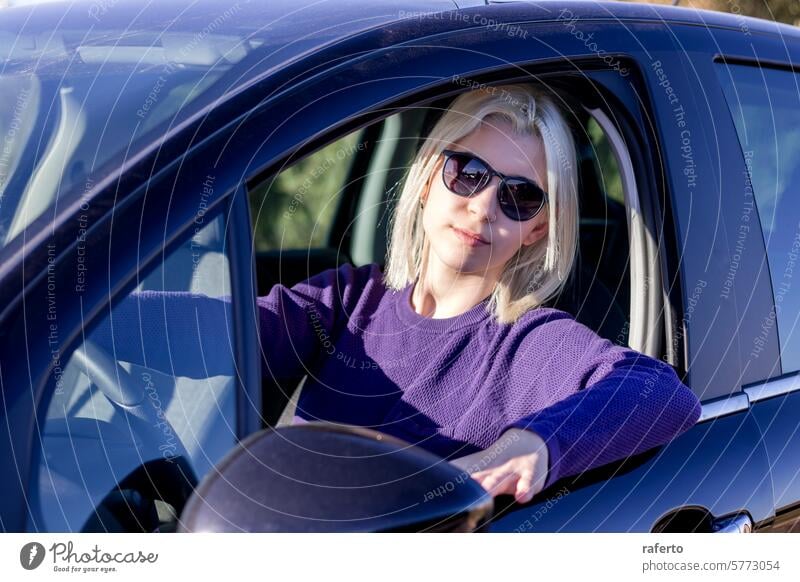 Blonde in sunglasses relaxed at car wheel blonde woman steering confident style automotive leisure fashion casual comfortable driving seat vehicle control pose