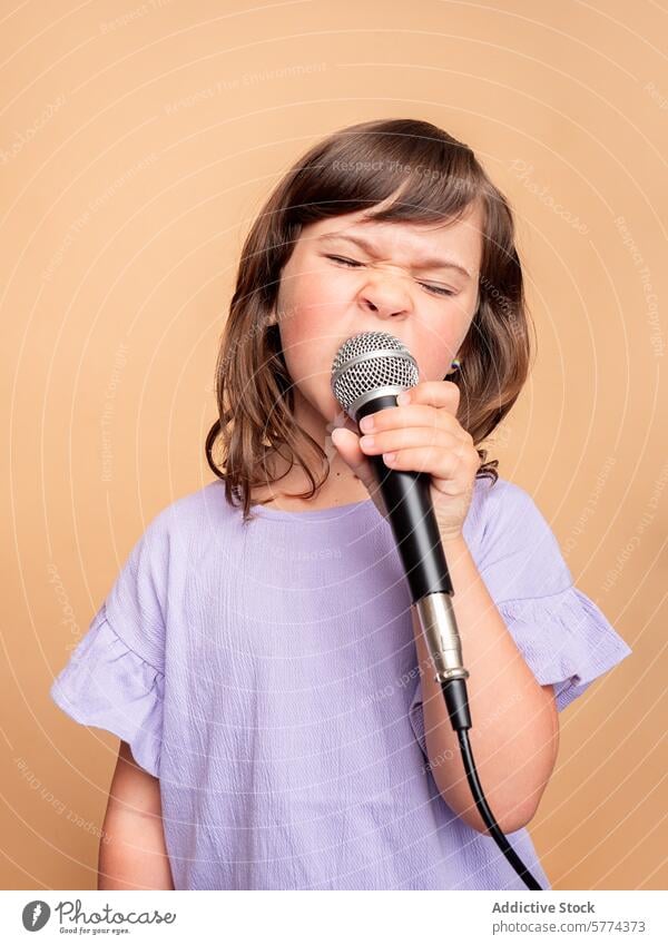 Young girl passionately singing into a microphone young beige background purple shirt child performance music talent grimace expression vocalist hobby