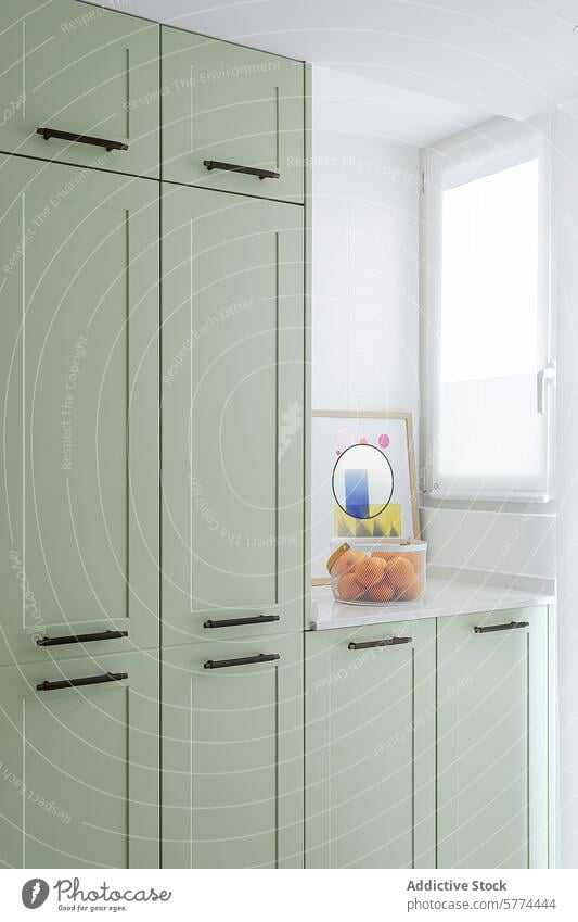 Pastel green kitchen cabinets in minimalist interior pastel design bright modern home decor storage furniture handle dark shelf wall abstract art basket fruit