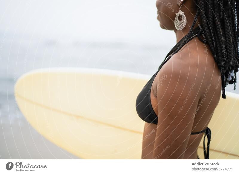 African American woman with surfboard on a foggy beach african american black girl leisure sport diversity contemplative young ethnic summer lifestyle sea ocean