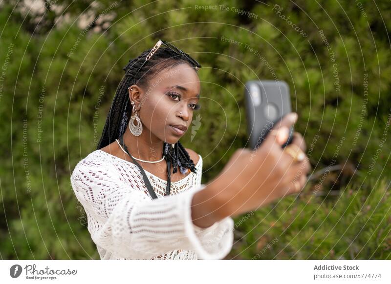 Young Black Girl Taking Selfie Outdoors girl black selfie smartphone outdoor greenery ethnic jewelry young vibe carefree african american casual style fashion