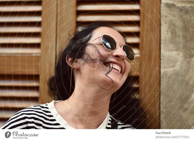 SMILING WOMAN - HAIR ON FACE - Woman black hair Curl Sunglasses Laughter joyfully Looking away pretty Hair on the face windy Summer vacation To enjoy Time Happy