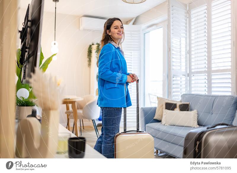 Young woman with her suitcase in a rented apartment packing clothing vacations travel preparation people luggage one person bag tourism traveler tourist adult