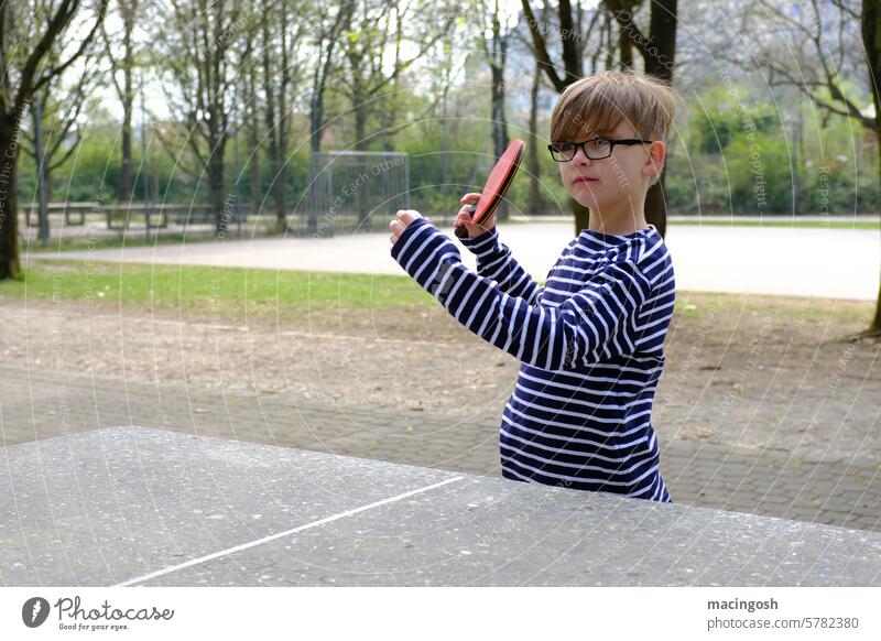 Little boy plays table tennis in the park Table tennis Table tennis bat Table tennis table ping-pong Ping-Pong Park Leisure and hobbies Sports Boy (child) Child