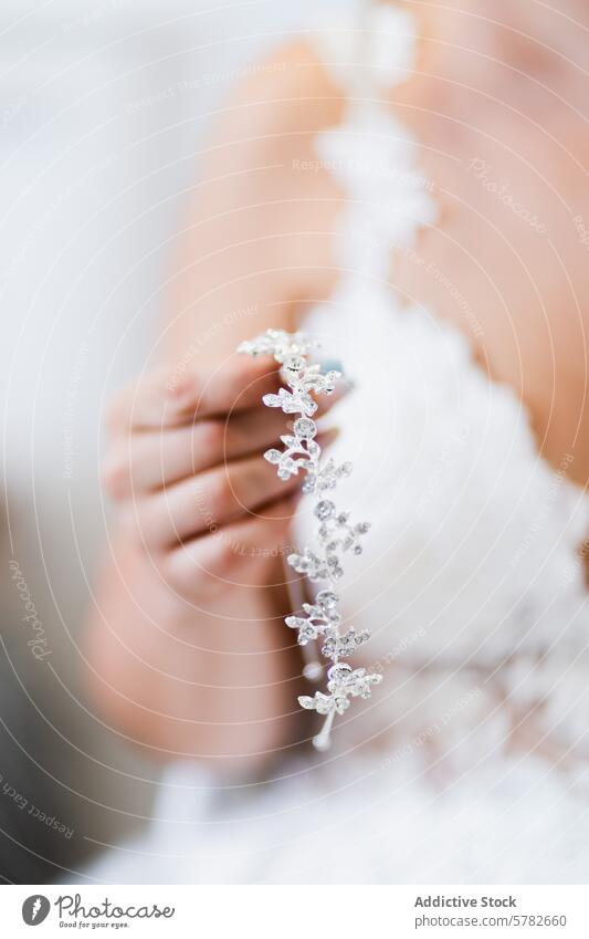 Bride Holding Silver Headpiece with Gown in Soft Focus bride wedding headpiece gown close-up bridal accessory silver soft focus marriage dress elegance fashion