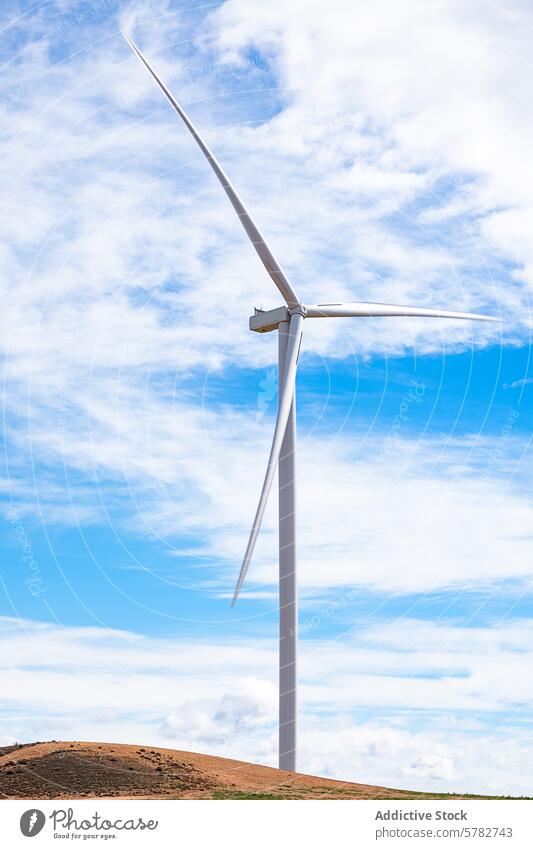 Majestic wind turbine against a cloudy blue sky sustainable energy modern environmental technology electricity power green eco-friendly renewable landscape