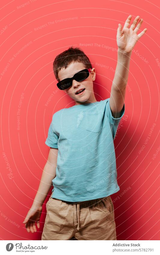 Cool young boy posing with sunglasses on pink background child cool playful pose fashion style vibrant casual t-shirt shorts fun cheerful kid youth modern