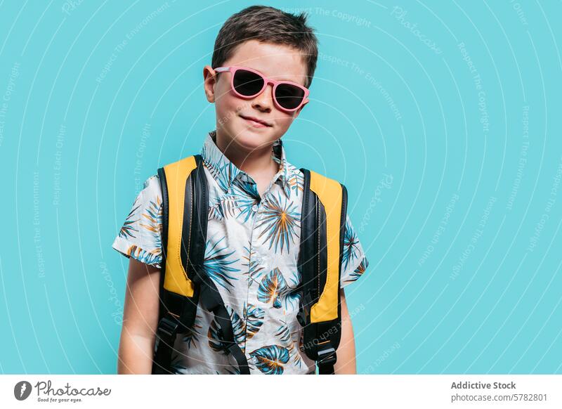 Young boy in summer outfit with sunglasses and backpack trendy tropical shirt fashion style adventure youth cool casual accessory fun childhood leisure modern