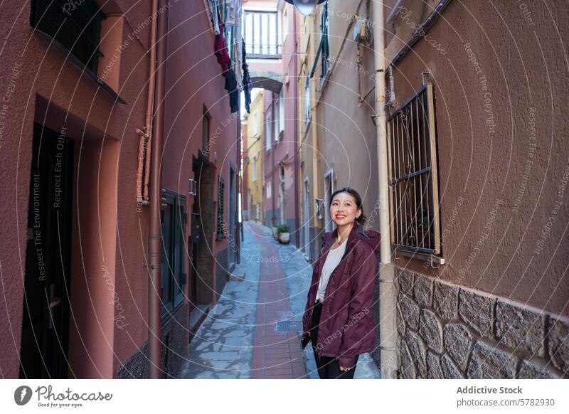 Tourist enjoying a picturesque Italian alley woman traveler tourist italy charming village narrow buildings colorful architecture smile Asian exploring quaint