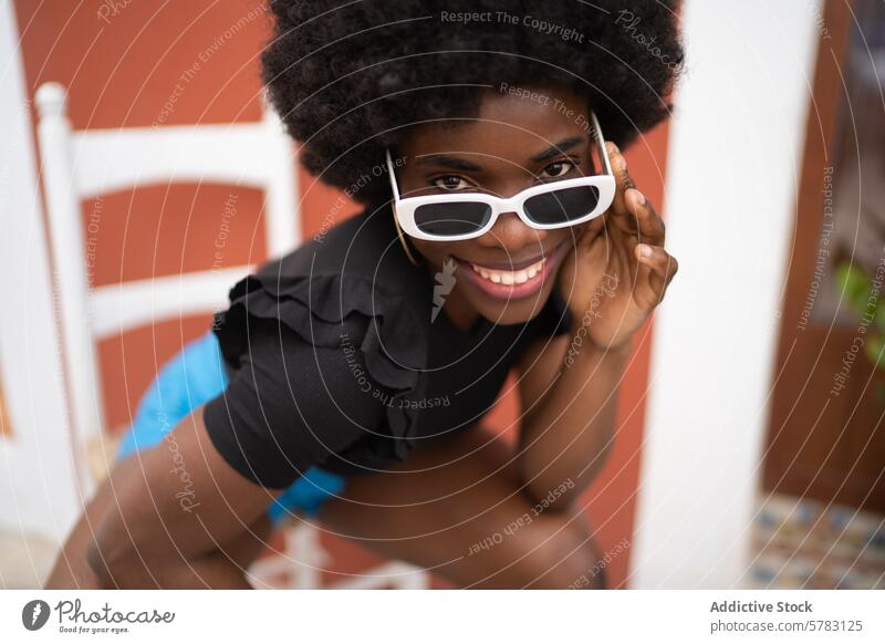 Vibrant smile of a young afro woman in stylish sunglasses african hairstyle cheerful white fashion joyful lifestyle playful vibrant natural beauty adult