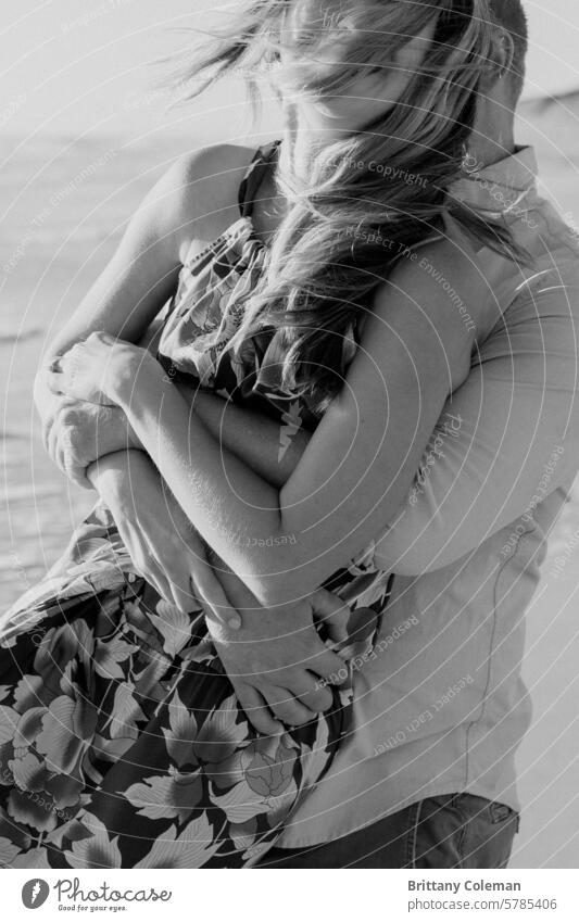 black and white image of man and woman hugging cuddle love engagement romantic couple Together together affection romance fondness embrace happy excited tender