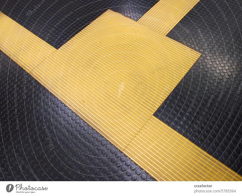 Gelbe Markierung auf schwarzem Noppenboden gelb Detail U-Bahnhof innen Boden Kontrast menschenleer Nahaufnahme Streifen