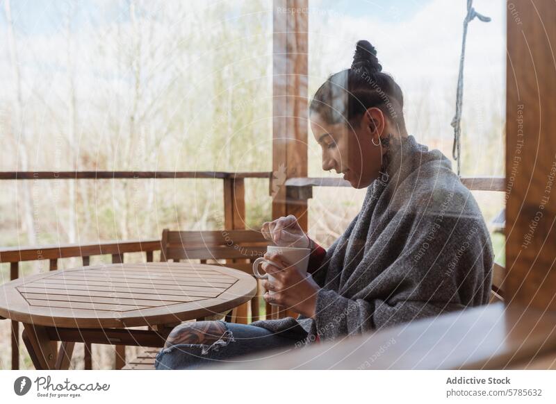 Serene moment of a woman enjoying coffee on porch nature tranquil serene blanket cozy wooden sipping relaxation morning calm outdoor seated leisure beverage cup
