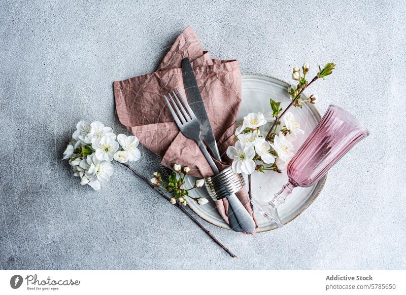 Elegant spring table decor with cherry blossoms setting elegant pastel color textured napkin silverware fork knife pink glass plate linen floral branch white