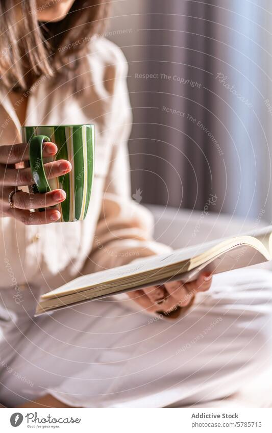 Anonymous relaxed woman with a book and coffee in the morning reading bed relaxation cozy warm drink leisure comfort peaceful enjoyment sitting lifestyle hobby