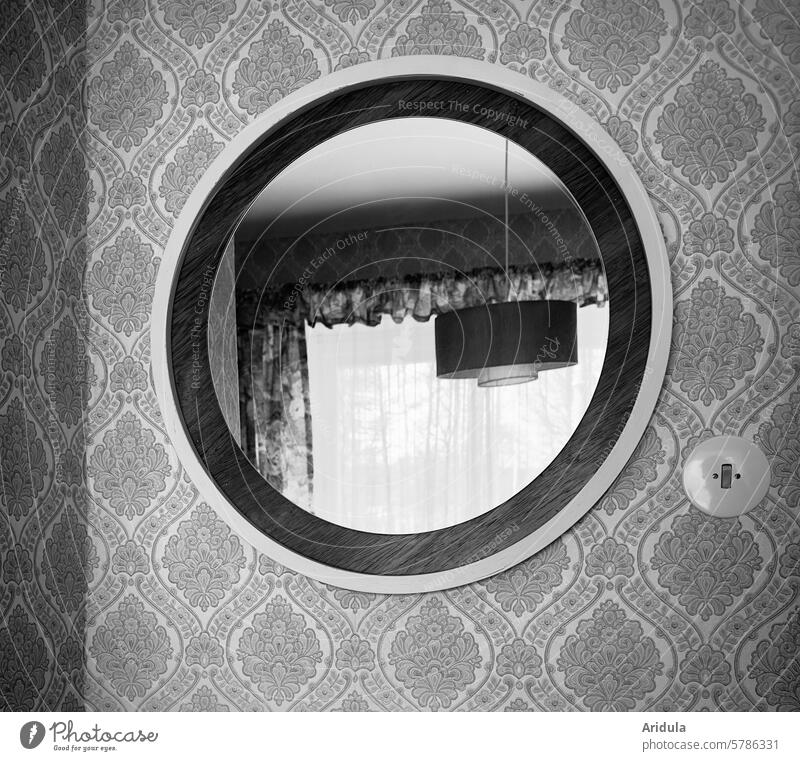 50s | old round mirror hangs on a patterned wall | a ceiling lamp and a window with curtains are reflected in the mirror fifties Retro Mirror Wall (building)