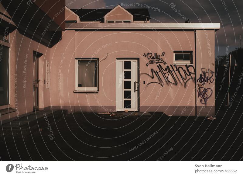 Graffiti on a house wall at sunrise Atmosphere sunny Light Summer Outdoors Day embassy sprayed Wall (barrier) Art illustration graffiti Damage to property Scene