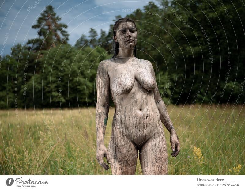 She’s definitely a wild spirit and is feeling free in her skin. A gorgeous naked girl outdoors with some black body paint melting on her. A nude portrait of a pretty woman on a fine summer day.