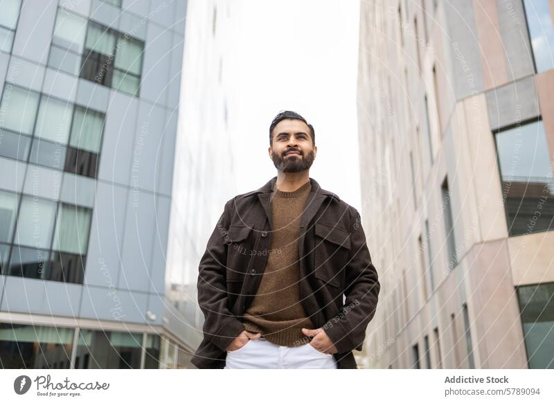 Confident urban man in casual fashion against buildings confident stylish brown jacket sweater outdoor modern architecture city lifestyle young adult male
