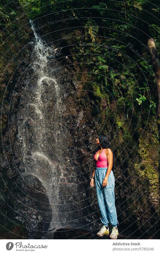 Woman marveling at a waterfall in lush Costa Rican forest woman costa rica nature greenery tranquil serene tropical jungle adventure travel natural beauty