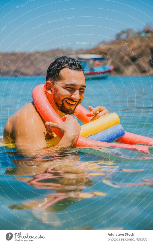 Man enjoying a sunny day at sea with colorful float man noodle swim water costa rica coastline happy beard vacation floating clear water leisure swimming