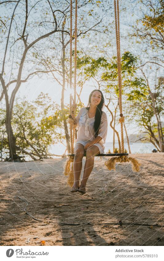 Serene swing moment at Costa Rican beach woman costa rica serene peaceful relaxation trees shade rope young enjoyment coast tropical leisure vacation travel