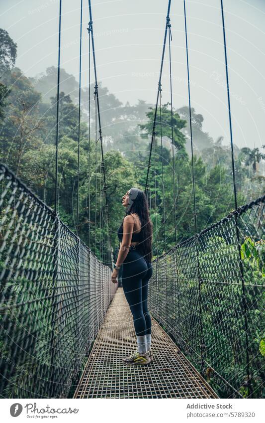 Exploring the misty rainforest from a hanging bridge woman costa rica lush nature serenity green exploration adventure travel outdoors tropical jungle