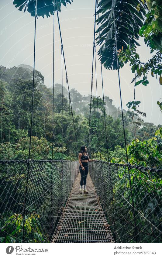 Jungle adventure on a hanging bridge in Costa Rica costa rica jungle travel rainforest tropical solo traveler nature exotic woman walking canopy exploration
