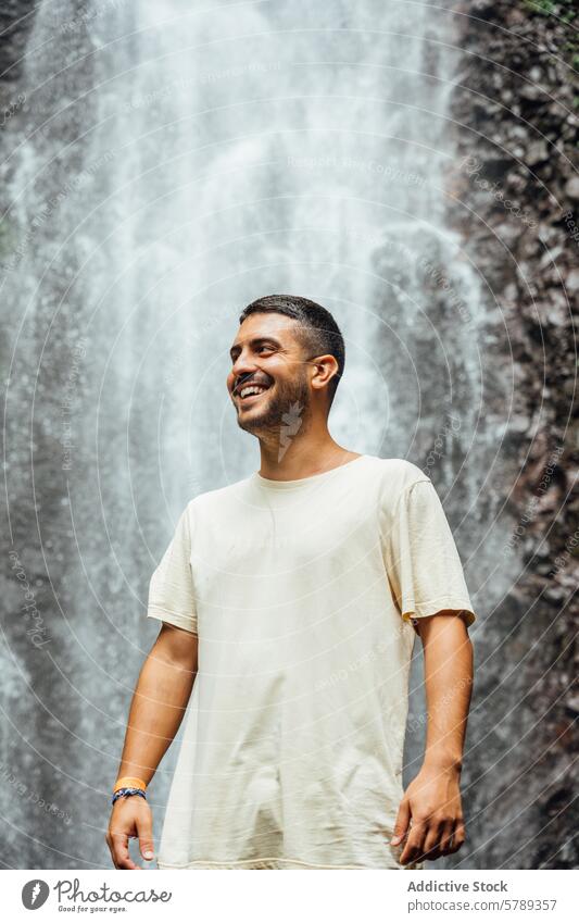 Smiling Man in Front of Costa Rican Waterfall man smiling waterfall costa rica travel adventure joy serenity nature outdoors leisure happiness male joyous