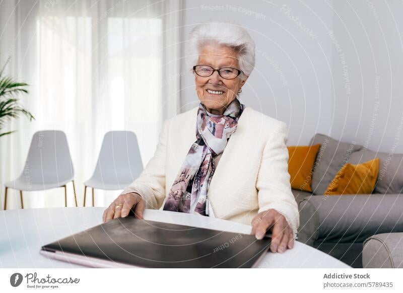 Elderly woman with laptop at home showing joy in work elderly senior working cheerful smile indoor technology user retired active aging internet casual comfort