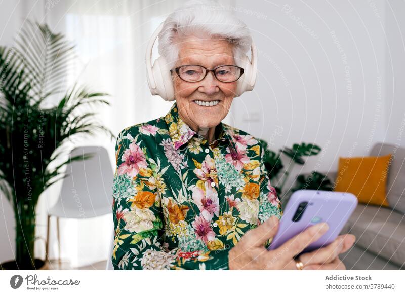 Senior Woman Enjoying Music at Home with Smartphone senior woman elderly headphones smartphone music home cheerful white hair happy technology modern leisure