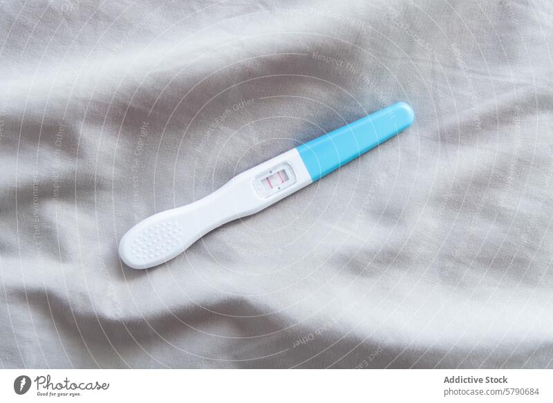 Positive pregnancy test on a grey fabric background positive result maternity anticipation medical health fertility parenthood motherhood life beginning family