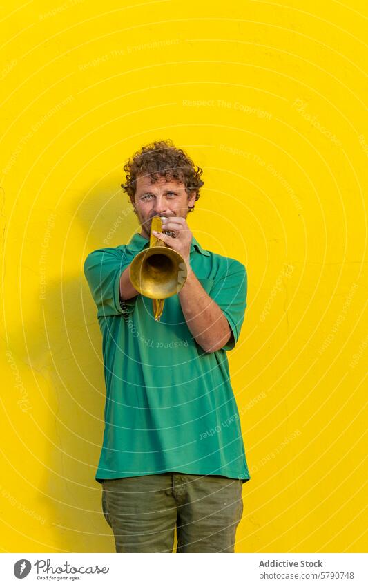 One-armed trumpeter performing against yellow wall one-armed man street performer music performance musician one arm disability playing outdoor male focus