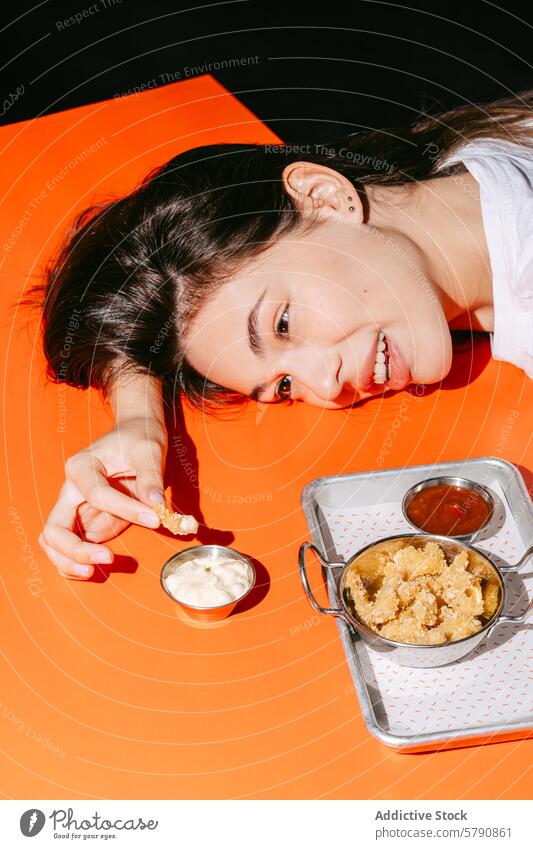 Enjoying Light Snacks with Dipping Sauces young person snack crispy dip sauce dipping selection orange background casual dining pleasure enjoyment eating food