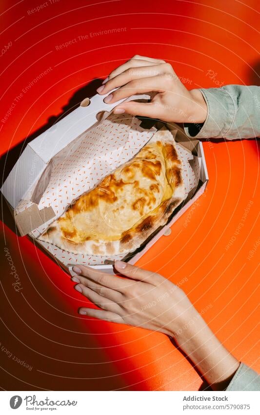 Golden Cheburek in Takeout Box on Vibrant Red cheburek baked takeout box woman hands golden pattern vibrant red orange cuisine pastry meal snack comfort food