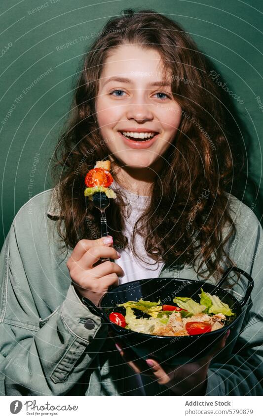 Young woman enjoying a fresh Caesar salad caesar eating cheerful smile casual dining bite ingredients youthful happiness enjoyment bowl tomato crouton lettuce