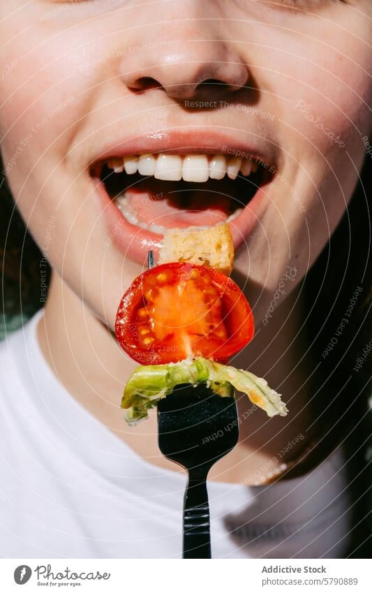 Close-up of fresh salad bite on a fork held by a smiling person woman tomato lettuce crouton healthy snack white background close-up cheerful enjoyment meal