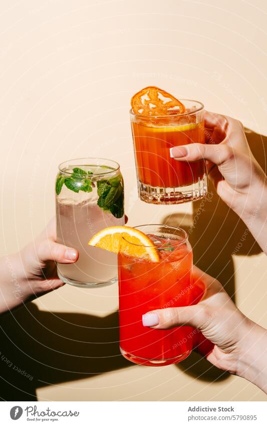 Anonymous trio of Refreshing Cocktails Held by Friends hand hold cocktail mojito berry-orange lemonade bloody mary drink beverage alcohol glass ice refreshment